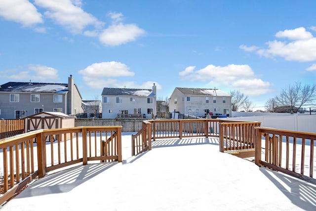 snow covered deck with a shed