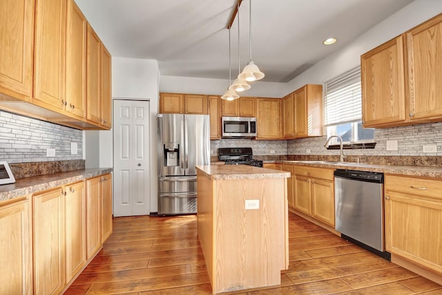 kitchen with stainless steel appliances, decorative light fixtures, a center island, and light wood-type flooring