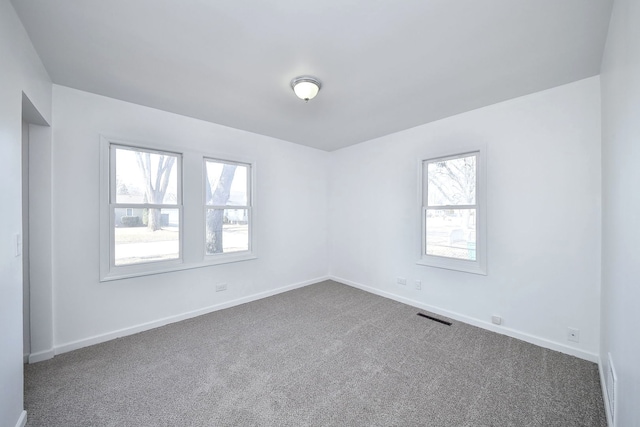 carpeted spare room featuring plenty of natural light