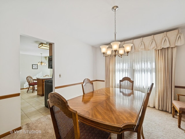 dining area with light colored carpet, light tile patterned floors, and an inviting chandelier