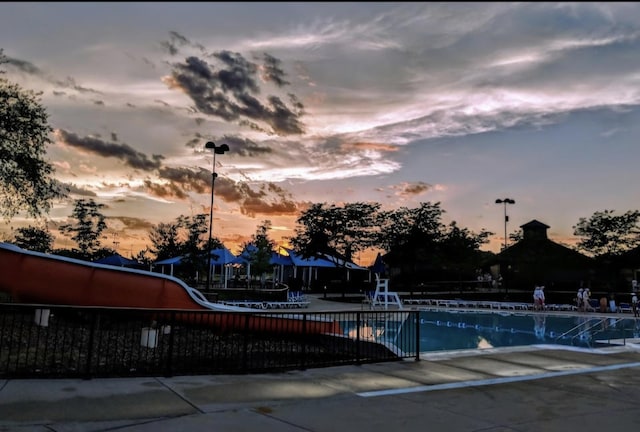 pool at dusk featuring a patio area