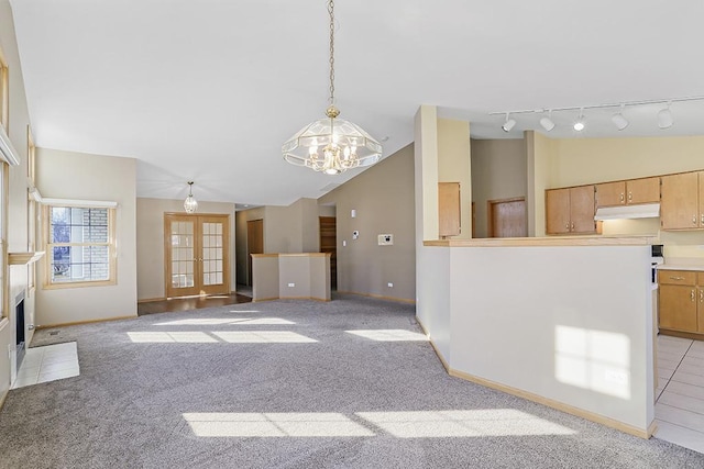 unfurnished living room with light carpet, lofted ceiling, french doors, and an inviting chandelier