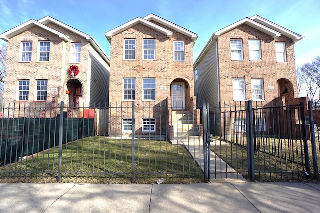 traditional-style house with brick siding, a fenced front yard, a front lawn, and a gate