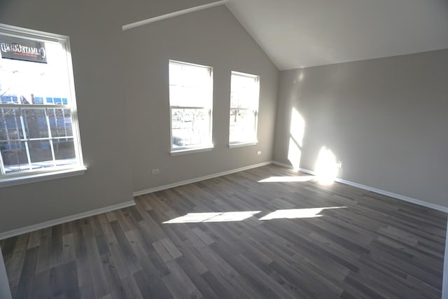 unfurnished room with dark wood-style flooring, vaulted ceiling, and baseboards