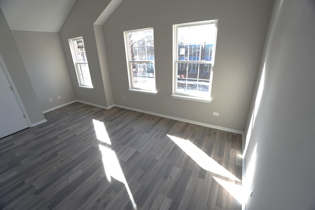 additional living space featuring lofted ceiling, dark wood-style floors, and baseboards