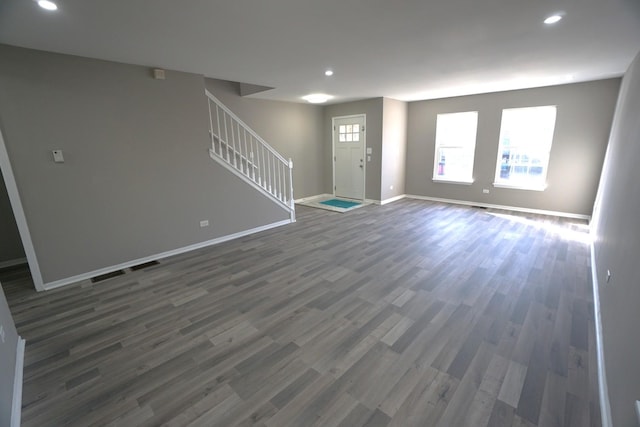 unfurnished living room with stairs, baseboards, dark wood-style flooring, and recessed lighting