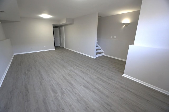 finished below grade area featuring wood finished floors, baseboards, and stairs