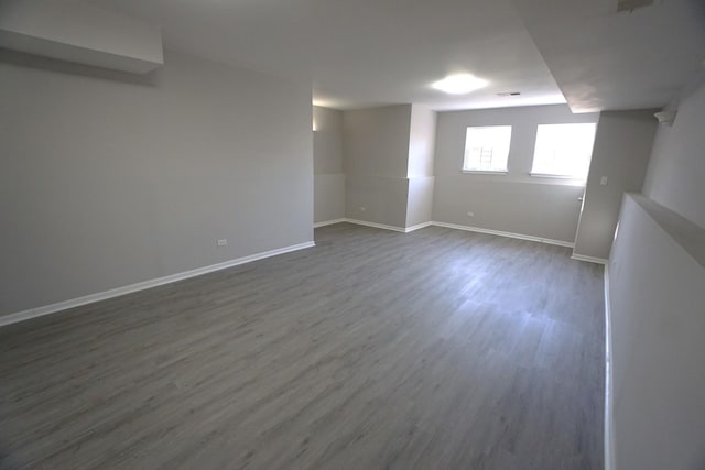 basement featuring wood finished floors, visible vents, and baseboards