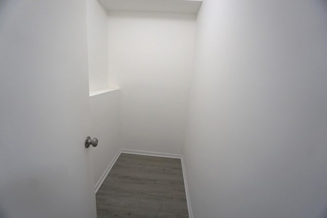 clothes washing area with baseboards and dark wood-style flooring