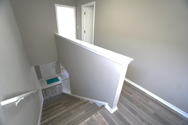 stairs featuring wood finished floors and baseboards