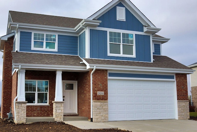 craftsman-style house with a shingled roof, a garage, stone siding, board and batten siding, and brick siding