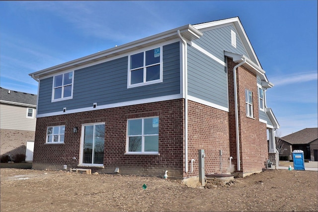 rear view of house featuring brick siding