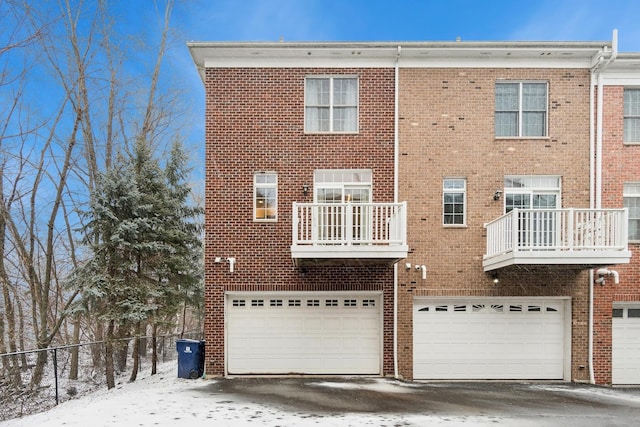 snow covered house with a balcony and a garage