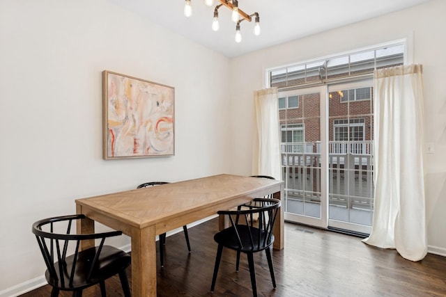 dining area featuring dark wood-type flooring and a chandelier