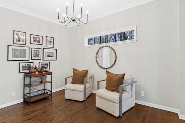 sitting room featuring ornamental molding, dark wood-type flooring, and a notable chandelier