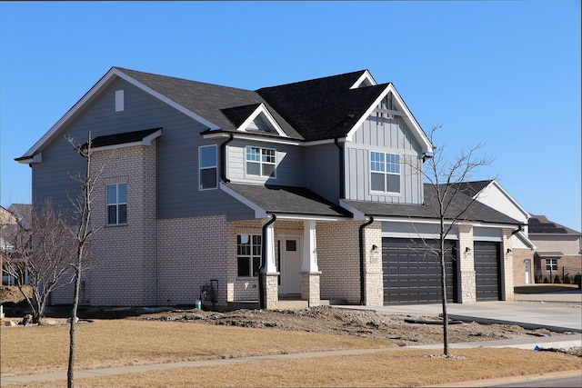 view of front of home featuring a garage, brick siding, board and batten siding, and concrete driveway