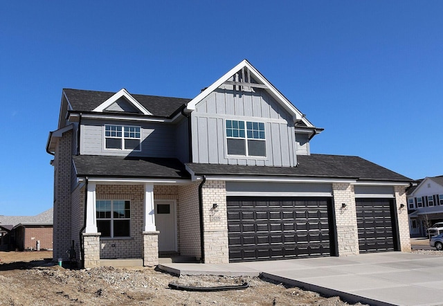 craftsman house featuring brick siding, board and batten siding, and driveway