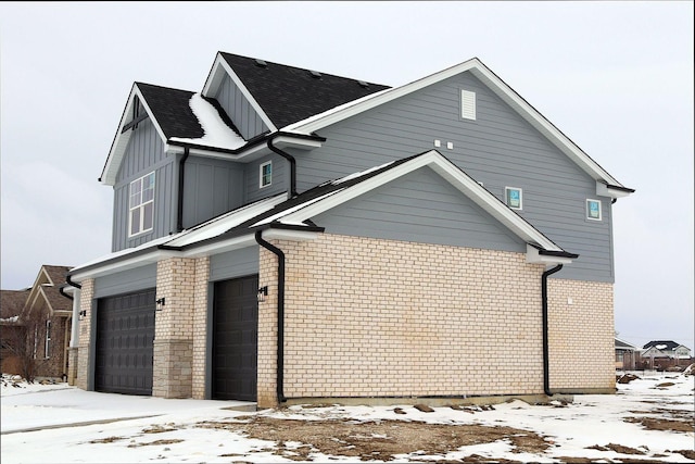 view of snowy exterior featuring a garage