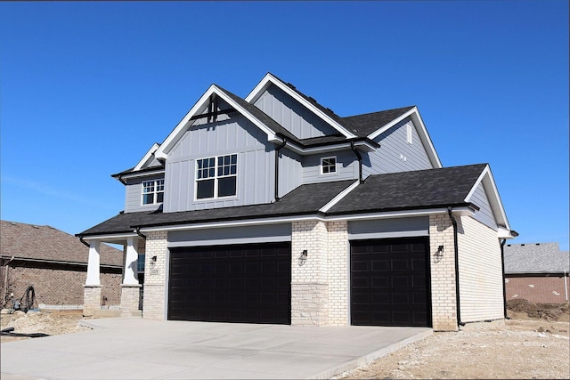 view of front facade with a garage, brick siding, board and batten siding, and concrete driveway