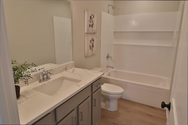 full bath featuring shower / bathing tub combination, toilet, wood finished floors, and vanity