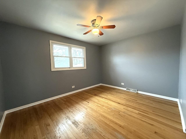 spare room featuring wood-type flooring and ceiling fan