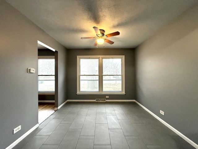 spare room featuring a textured ceiling and ceiling fan