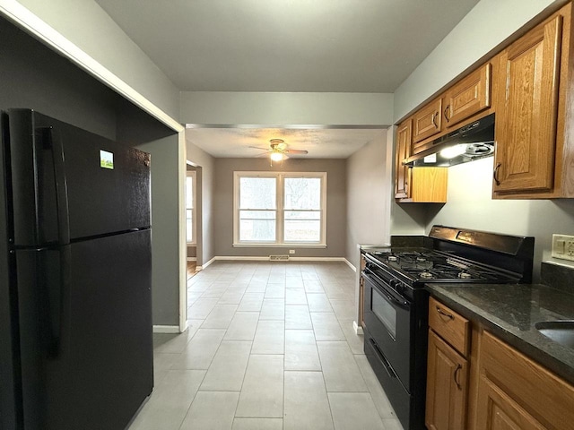 kitchen with light tile patterned floors, dark stone countertops, ceiling fan, and black appliances