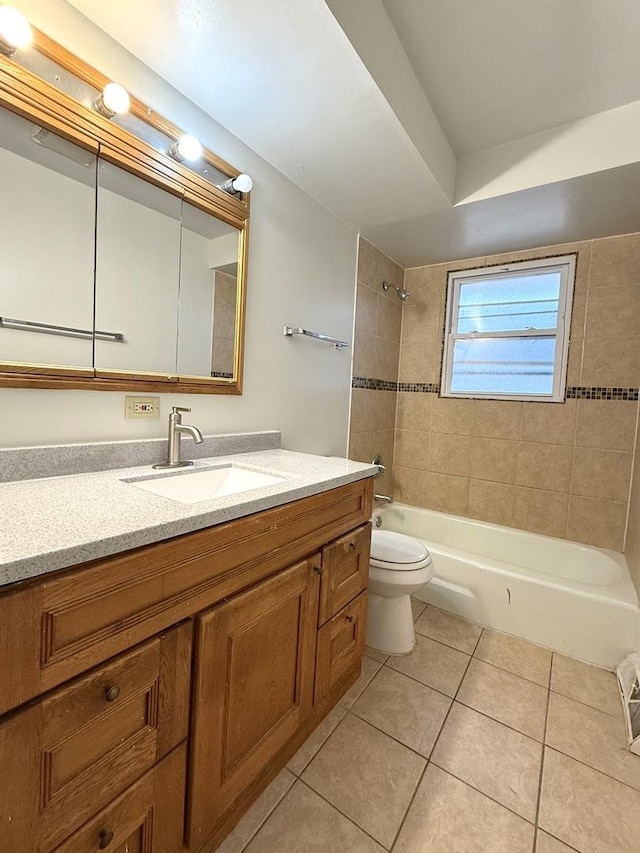 full bathroom featuring tiled shower / bath combo, vanity, tile patterned flooring, and toilet