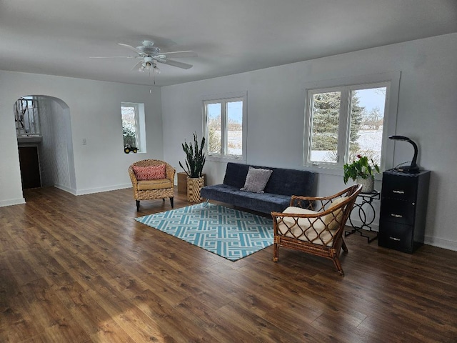 living room with ceiling fan and dark hardwood / wood-style flooring