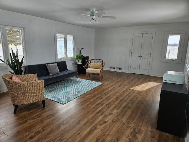 living room with a wealth of natural light, dark hardwood / wood-style floors, and ceiling fan