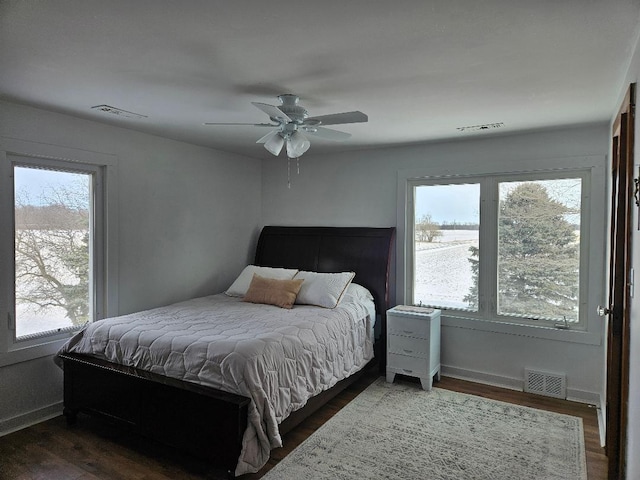 bedroom with dark hardwood / wood-style flooring and ceiling fan