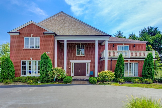 greek revival inspired property with a balcony