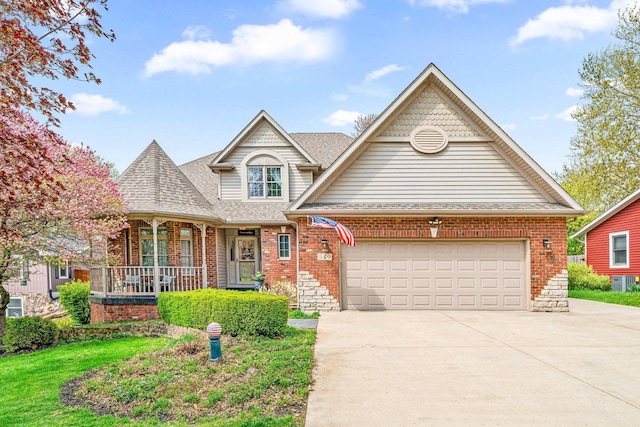 549 Beachview Dr, Lake Holiday, IL 60552 - view of front of home featuring roof with shingles, an attached garage, brick siding, concrete driveway, and covered porch