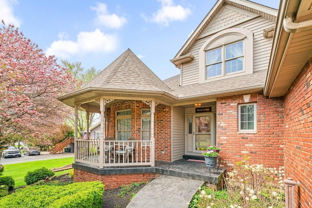 549 Beachview Dr, Lake Holiday, IL 60552 - entrance to property featuring a porch, brick siding, and a shingled roof