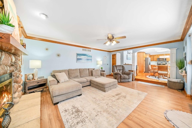 549 Beachview Dr, Lake Holiday, IL 60552 - living room featuring a ceiling fan, visible vents, crown molding, a fireplace, and light wood finished floors