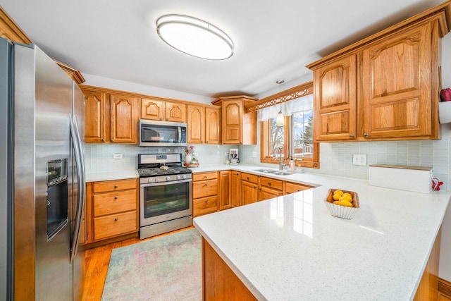 549 Beachview Dr, Lake Holiday, IL 60552 - kitchen featuring a sink, brown cabinetry, stainless steel appliances, a peninsula, and tasteful backsplash