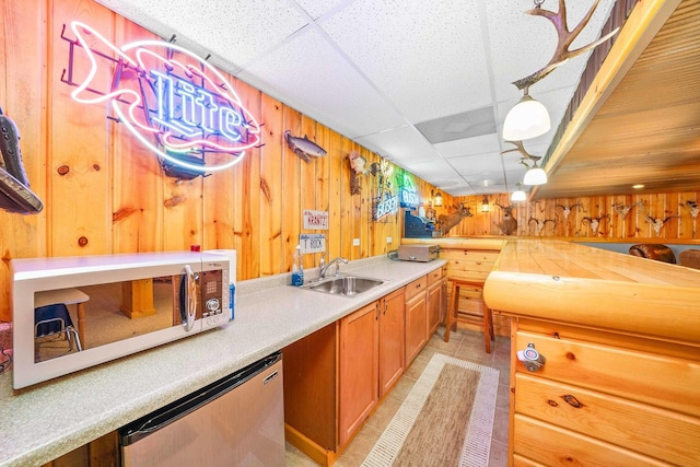 549 Beachview Dr, Lake Holiday, IL 60552 - kitchen featuring wooden walls, a sink, light countertops, a paneled ceiling, and white microwave
