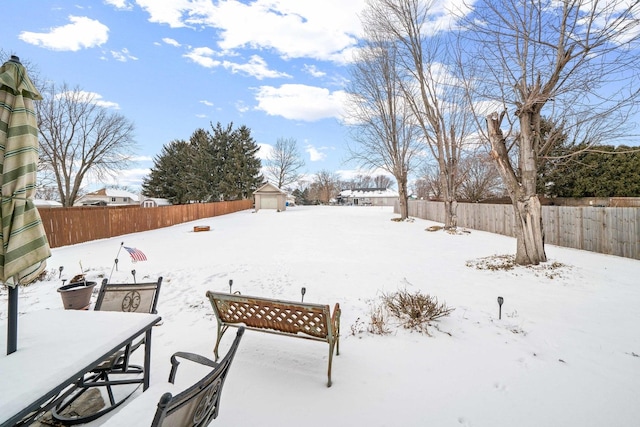 549 Beachview Dr, Lake Holiday, IL 60552 - yard layered in snow with an outdoor structure, a fenced backyard, outdoor dining space, and a shed