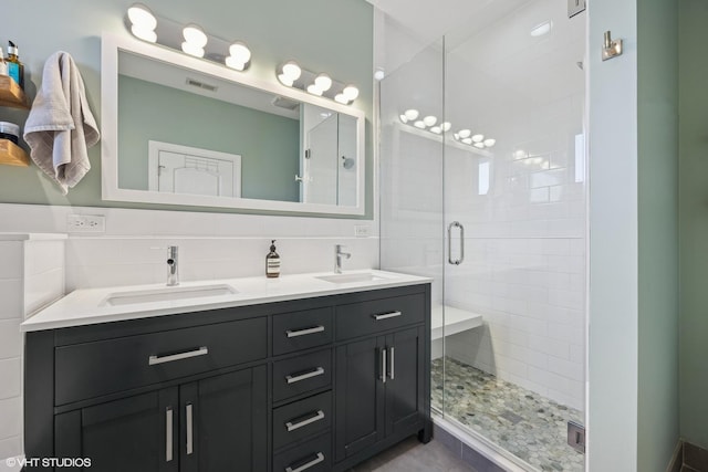 bathroom featuring tile walls, vanity, tasteful backsplash, and a shower with door