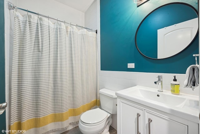 bathroom with tile walls, vanity, and toilet