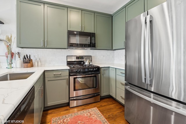 kitchen with decorative backsplash, dark wood-type flooring, black appliances, and green cabinetry