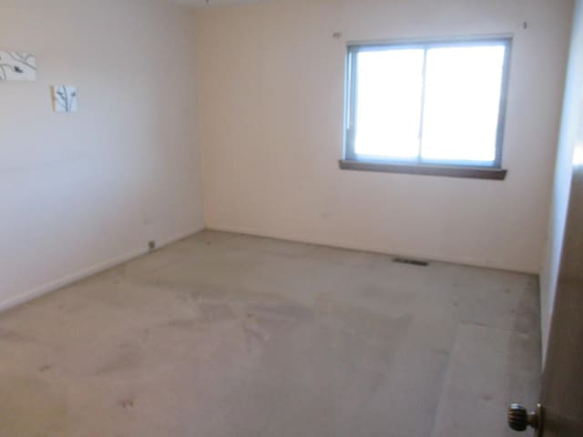 empty room featuring visible vents and carpet