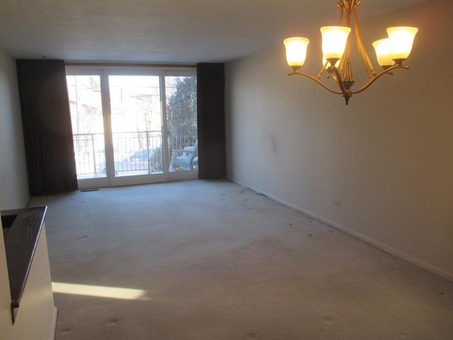 unfurnished room featuring carpet flooring and a chandelier