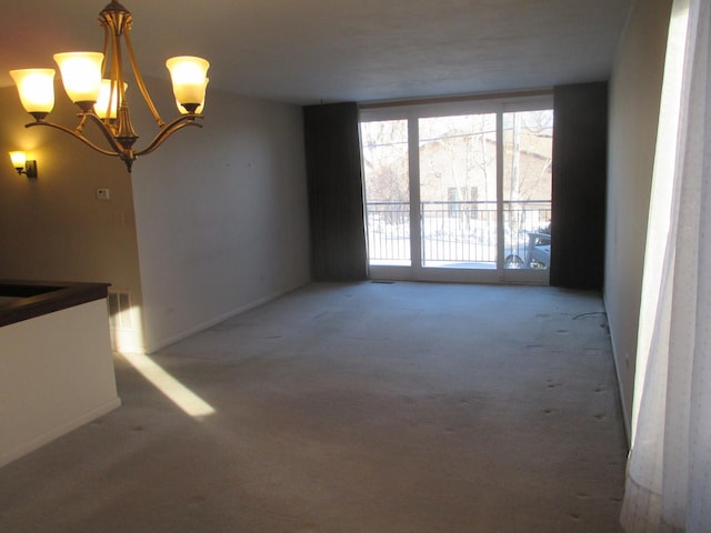 interior space with baseboards, an inviting chandelier, and carpet floors