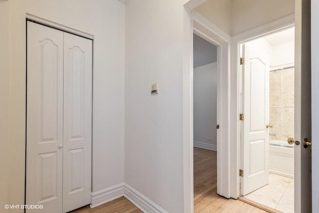 hallway with light wood finished floors and baseboards