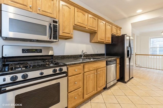 kitchen with light tile patterned floors, dark stone counters, appliances with stainless steel finishes, a sink, and recessed lighting