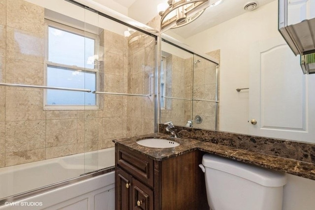 bathroom with toilet, visible vents, bath / shower combo with glass door, and vanity