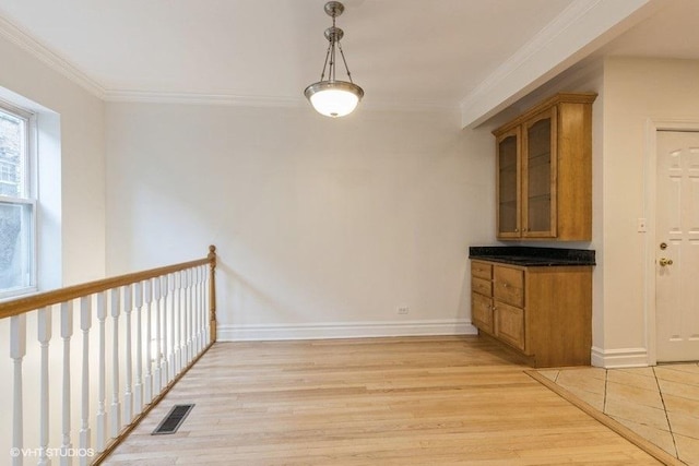 interior space featuring ornamental molding, visible vents, light wood-style floors, and baseboards