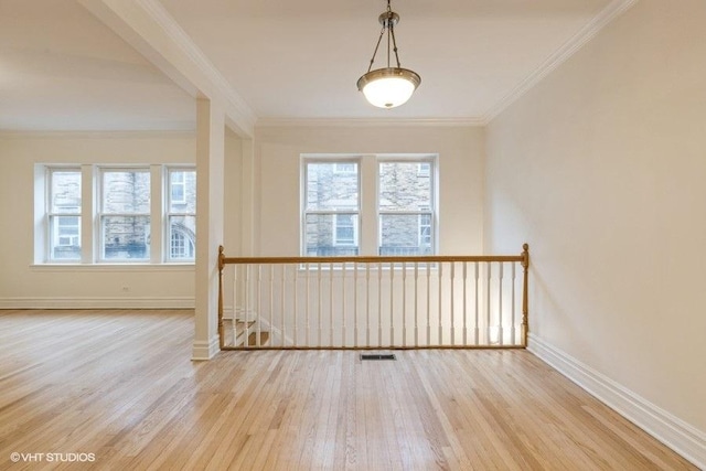 unfurnished room with wood finished floors, visible vents, and crown molding