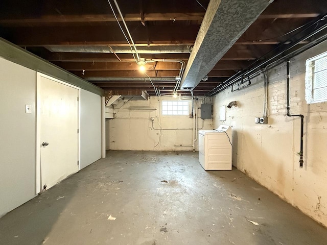 basement with electric panel and washer / dryer